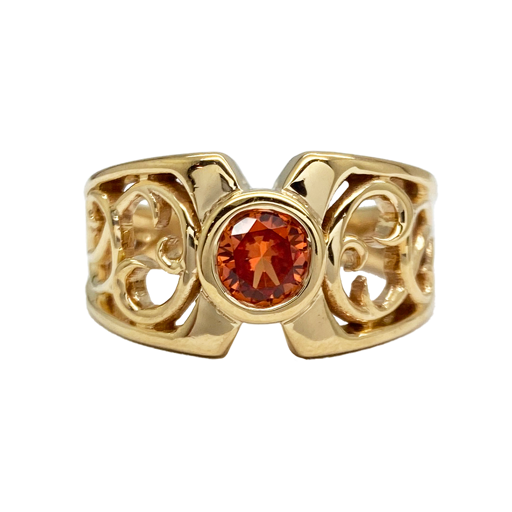 Gold ring with a round spessartite garnet set in an Art Nouveau-inspired filigree design.