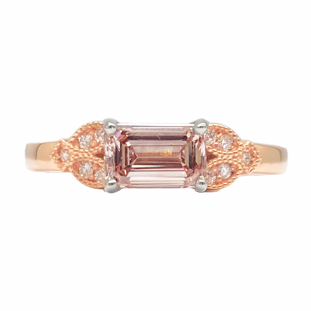 Rose gold ring with an emerald-cut pink sapphire center stone.