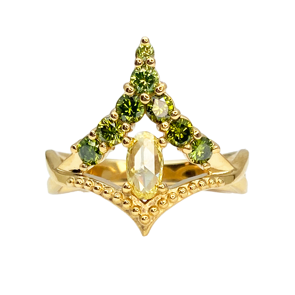 Yellow gold ring featuring a central oval diamond flanked by two rows of green gemstones in a triangular setting.