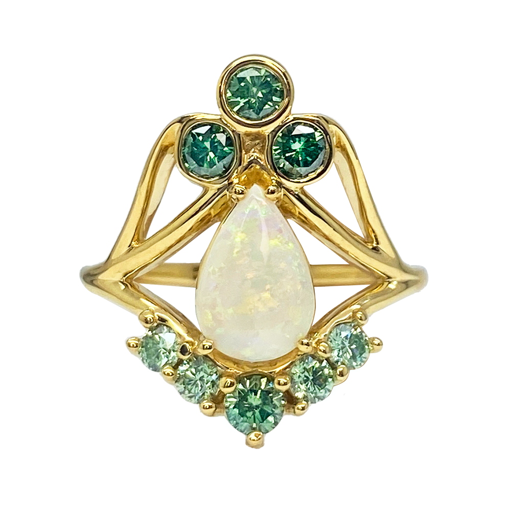 Gold ring featuring a pear-shaped opal surrounded by a cluster of green diamonds and smaller accent diamonds.