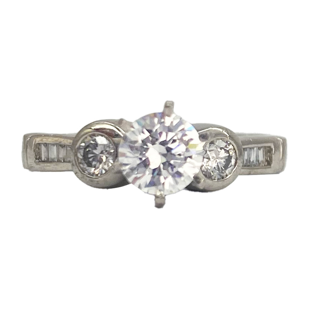Three-stone diamond ring with a round center stone and two smaller round side stones, all set in a silver band