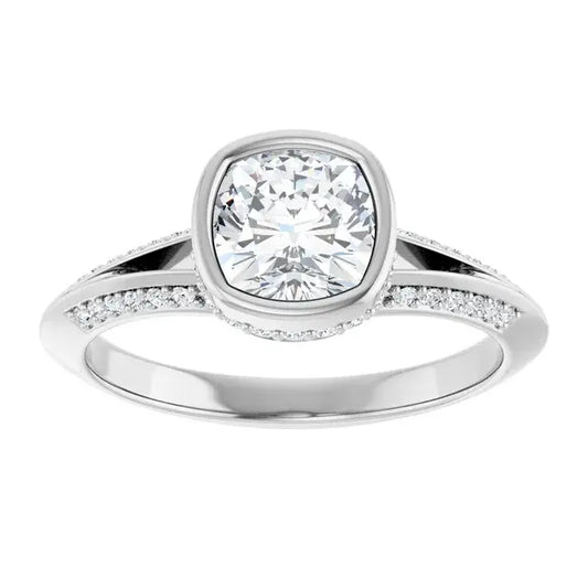 Silver ring with a large diamond and smaller diamonds on the band against a white background