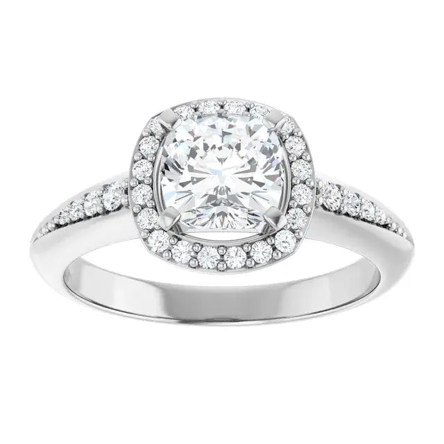 Silver ring with a large central gemstone and smaller stones around on a white background