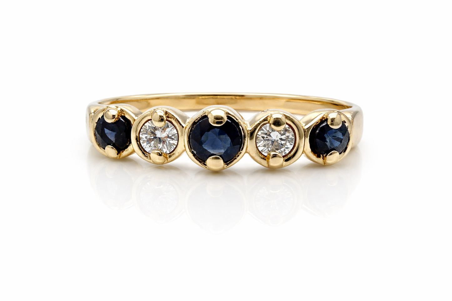 Gold ring with blue gemstones and diamonds on a white background