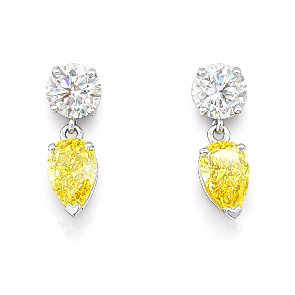 Pair of earrings with yellow pear-shaped gemstones and clear round stones on a white background