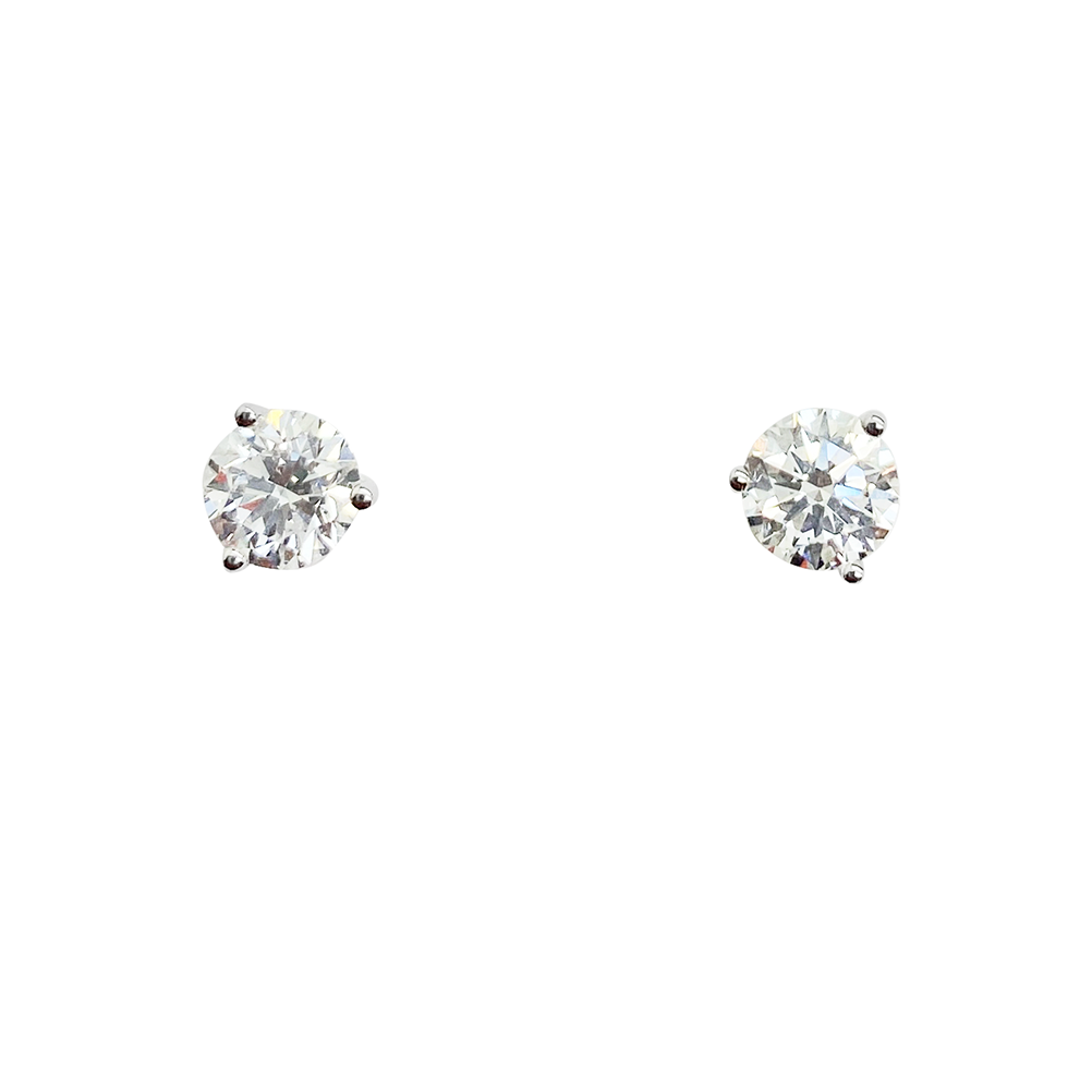Pair of white gold single diamond stud earrings on a white background