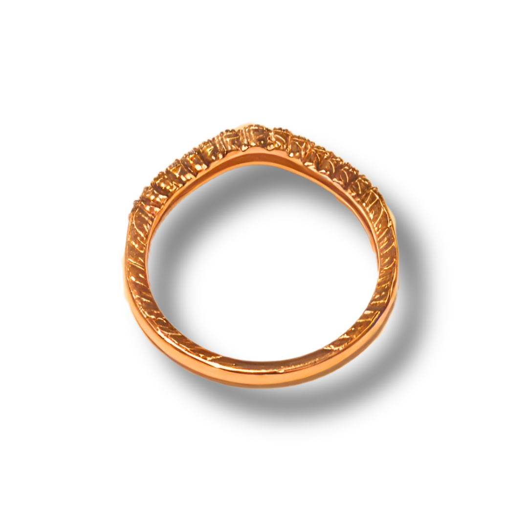 Gold wedding band with a curved design and diamond accents, on a white background