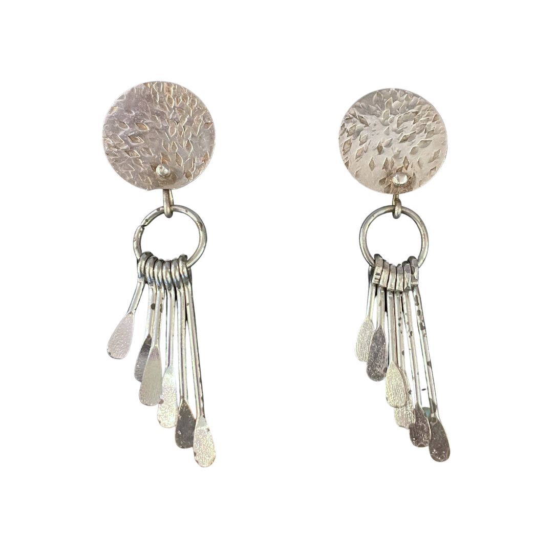 Pair of silver earrings with circular tops and dangling elements on a white background