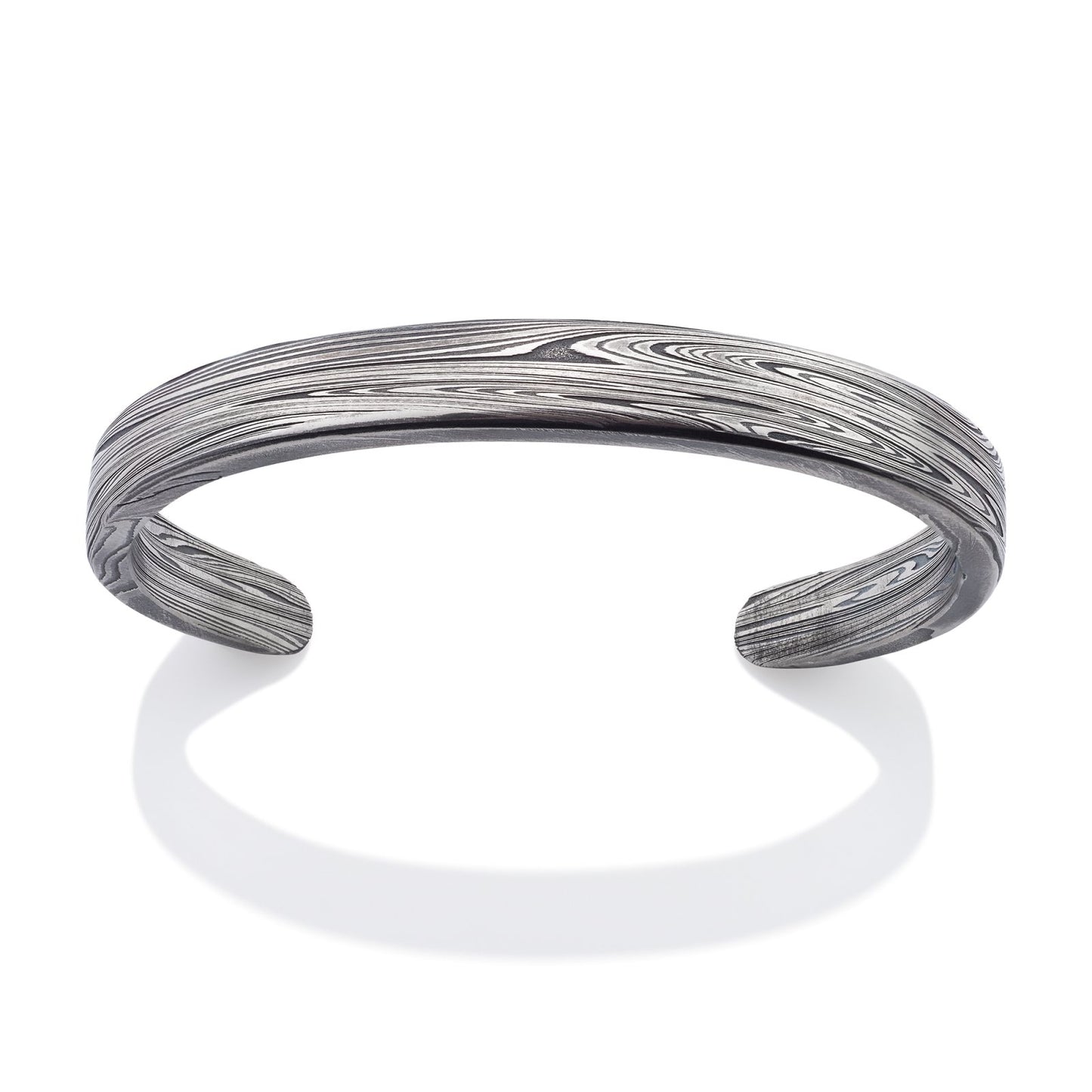 Silver cuff bracelet with a Damascus steel pattern on a white background