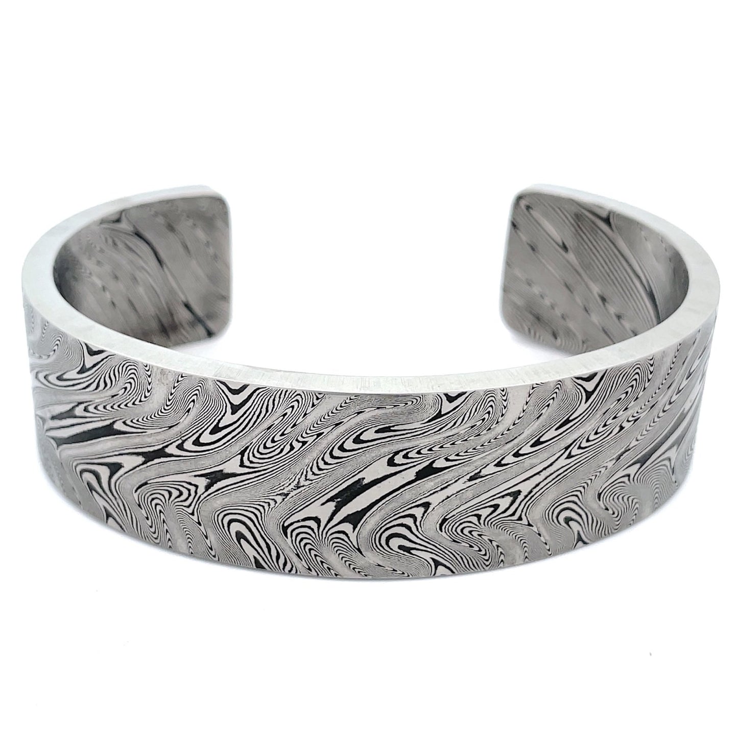 Titanium cuff bracelet with Damascus steel pattern on a white background.