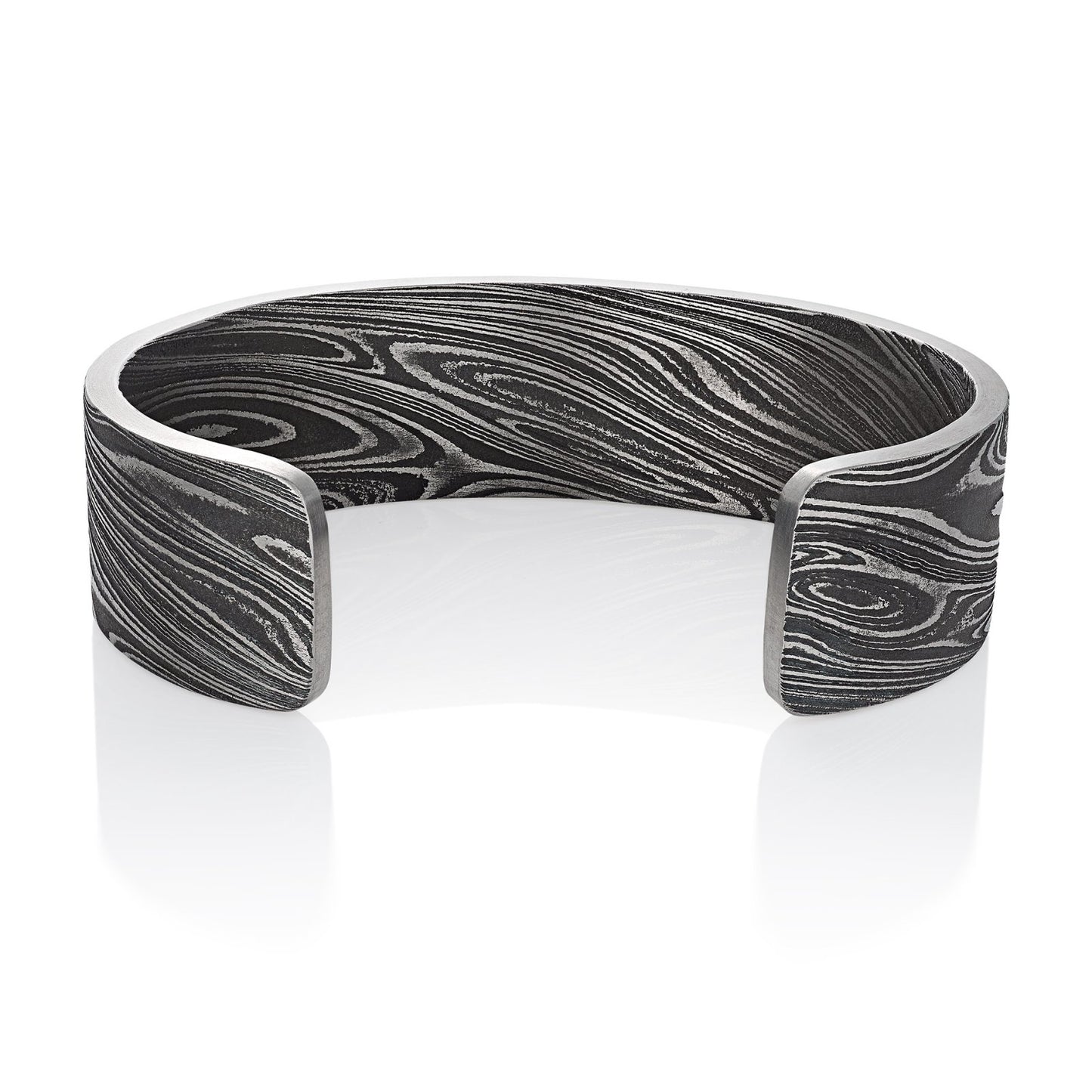 Titanium cuff bracelet with Damascus steel pattern on a white background.