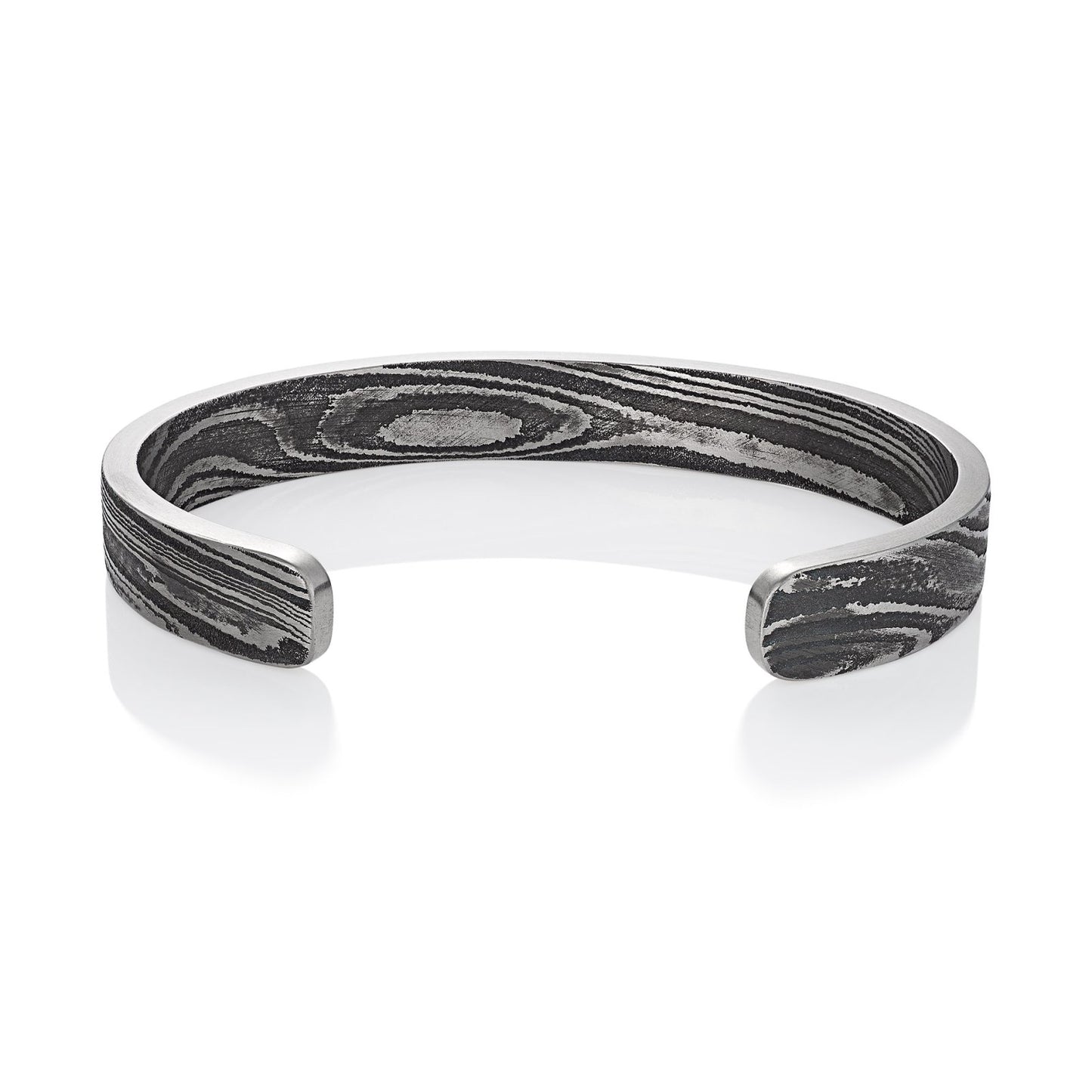 Titanium cuff bracelet with Damascus steel pattern on a white background.