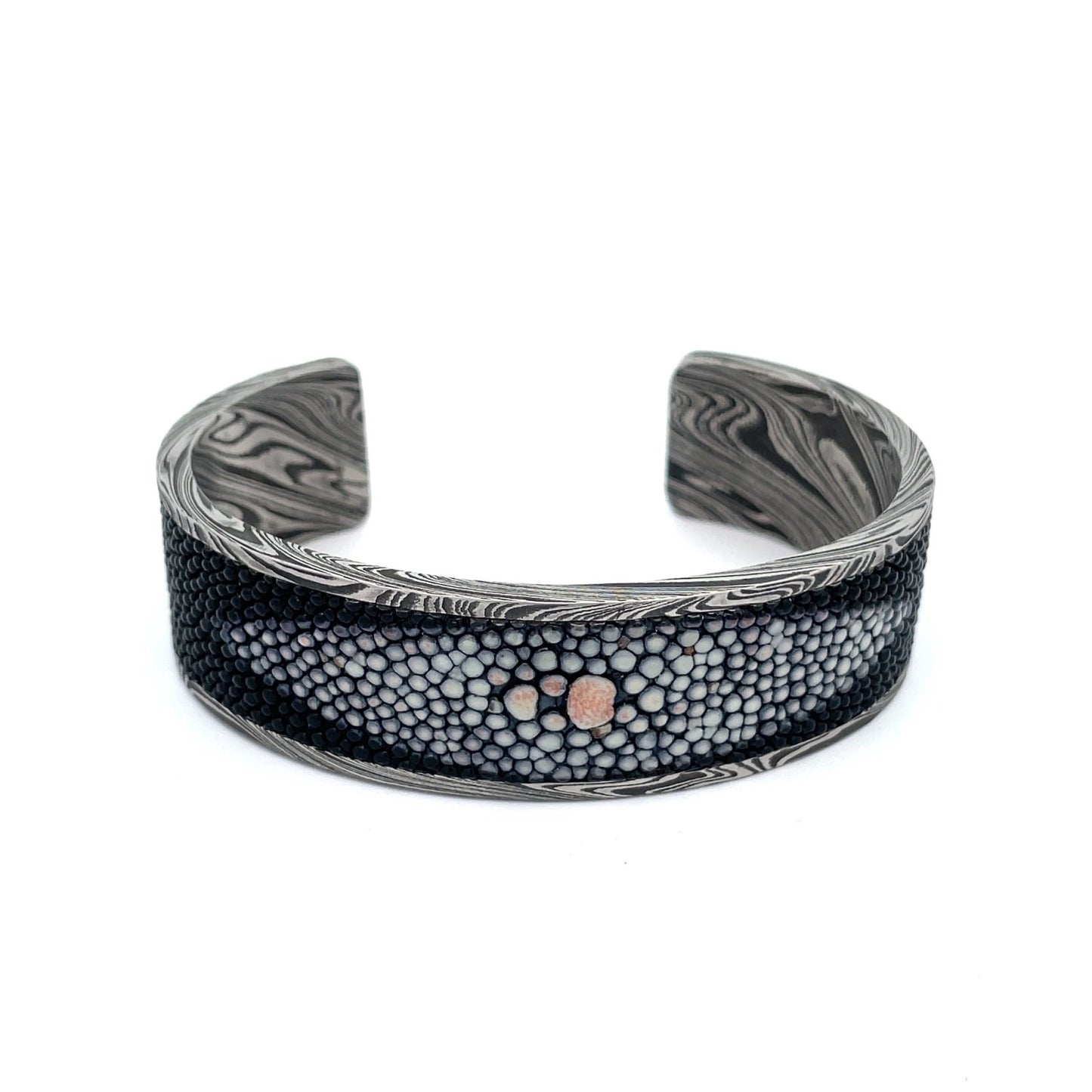 Titanium cuff bracelet with Damascus steel pattern on a white background.