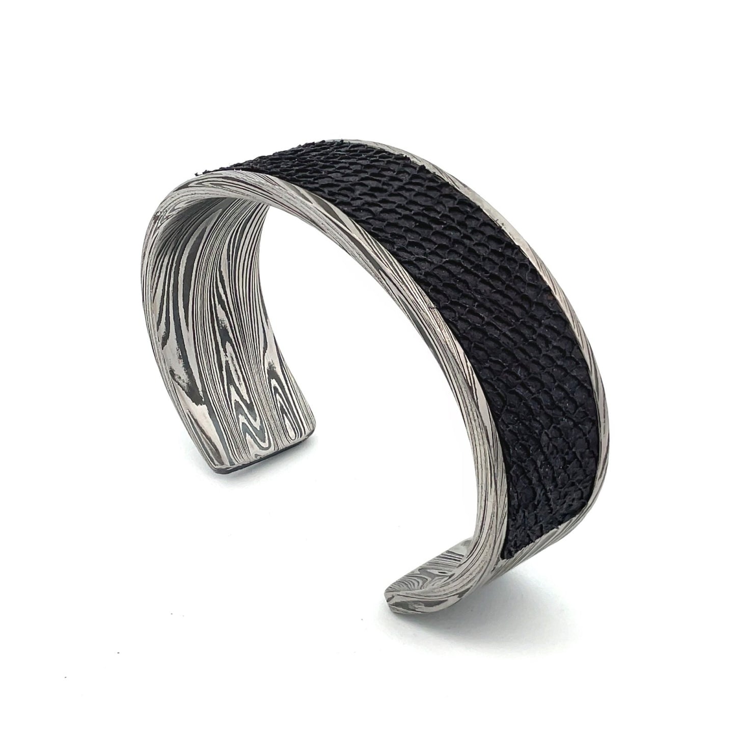 Titanium cuff bracelet with Damascus steel pattern on a white background.