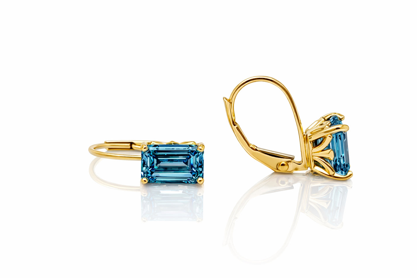 Gold earrings with blue gemstones on a white background