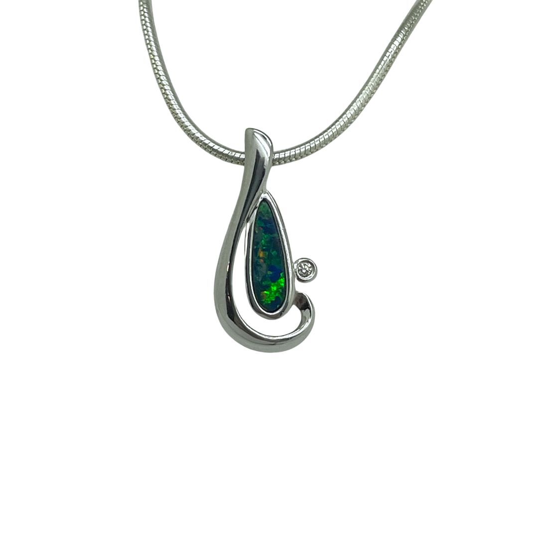 Silver pendant with a green gemstone on a white background
