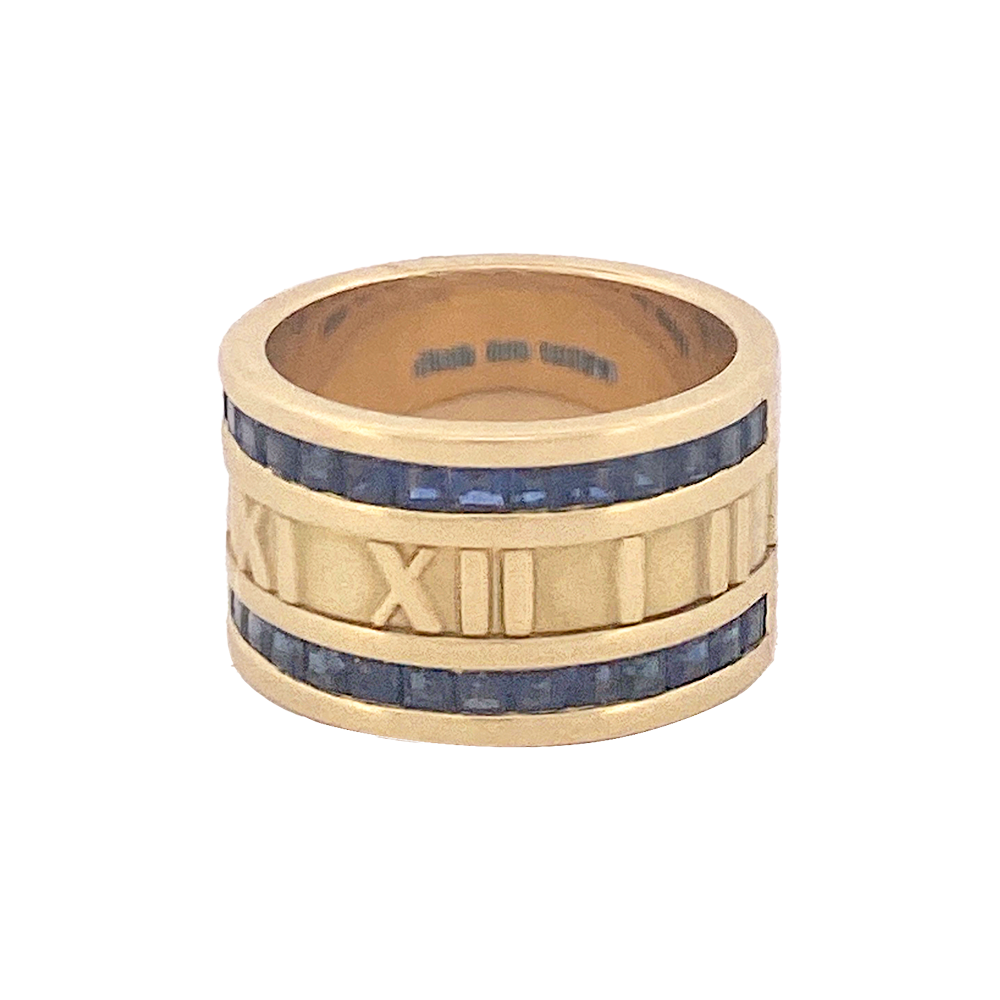 Gold ring with blue inlay and Roman numeral design on a white background