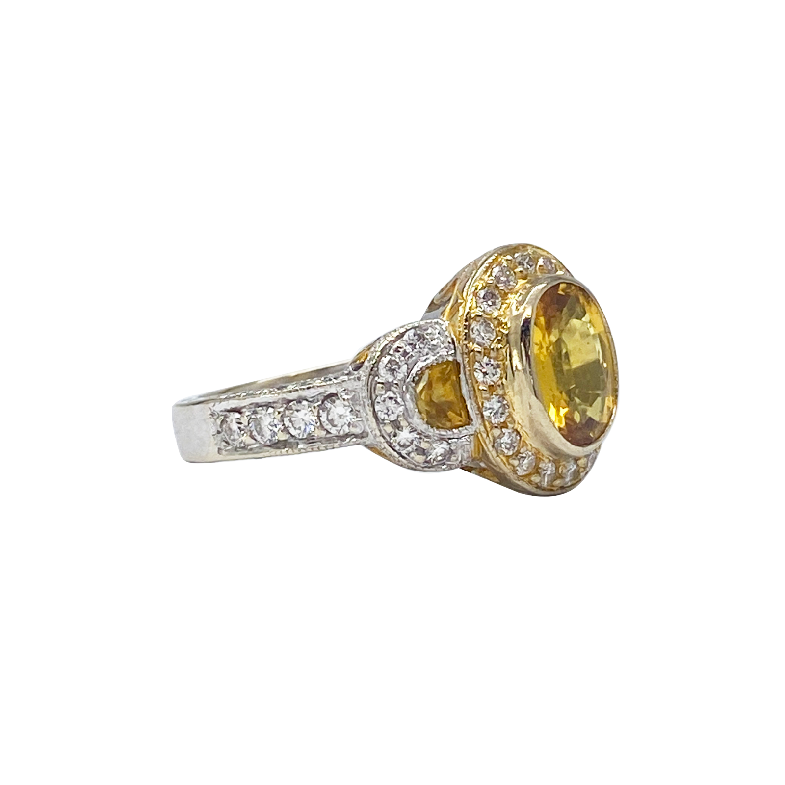Gold and silver ring with a yellow gemstone on a white background