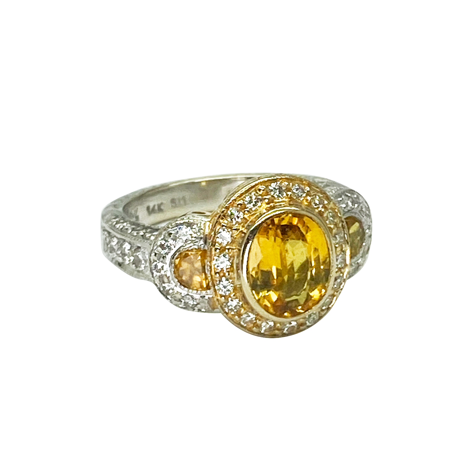 Gold and silver ring with a yellow gemstone on a white background