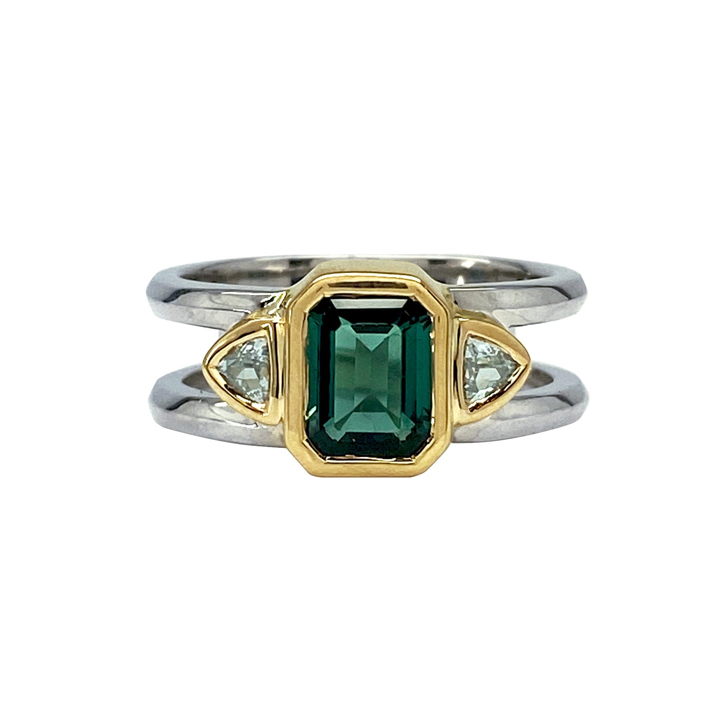 Two-tone ring featuring an emerald-cut green tourmaline center stone flanked by triangular aqua-colored sapphires.
