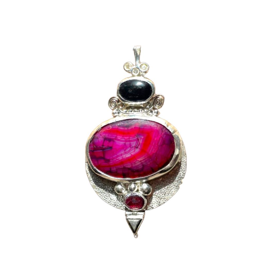 Jewelry pendant with pink stone, black gem, and red gem on a white background