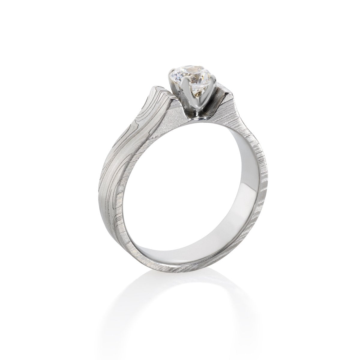 Silver engagement ring with an oval diamond and a Damascus steel band on a white background