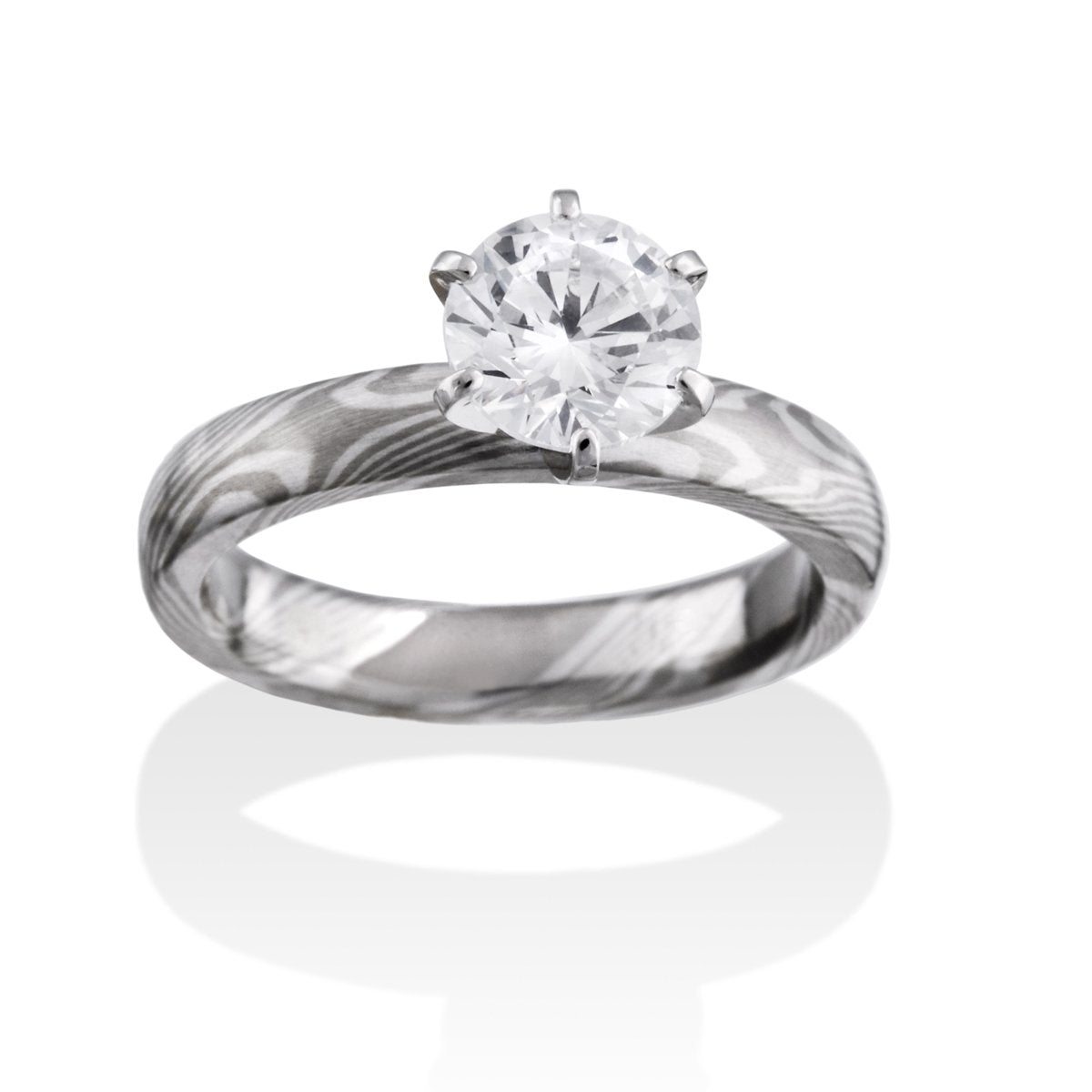 Silver ring with a round diamond and a Damascus steel band on a white background.