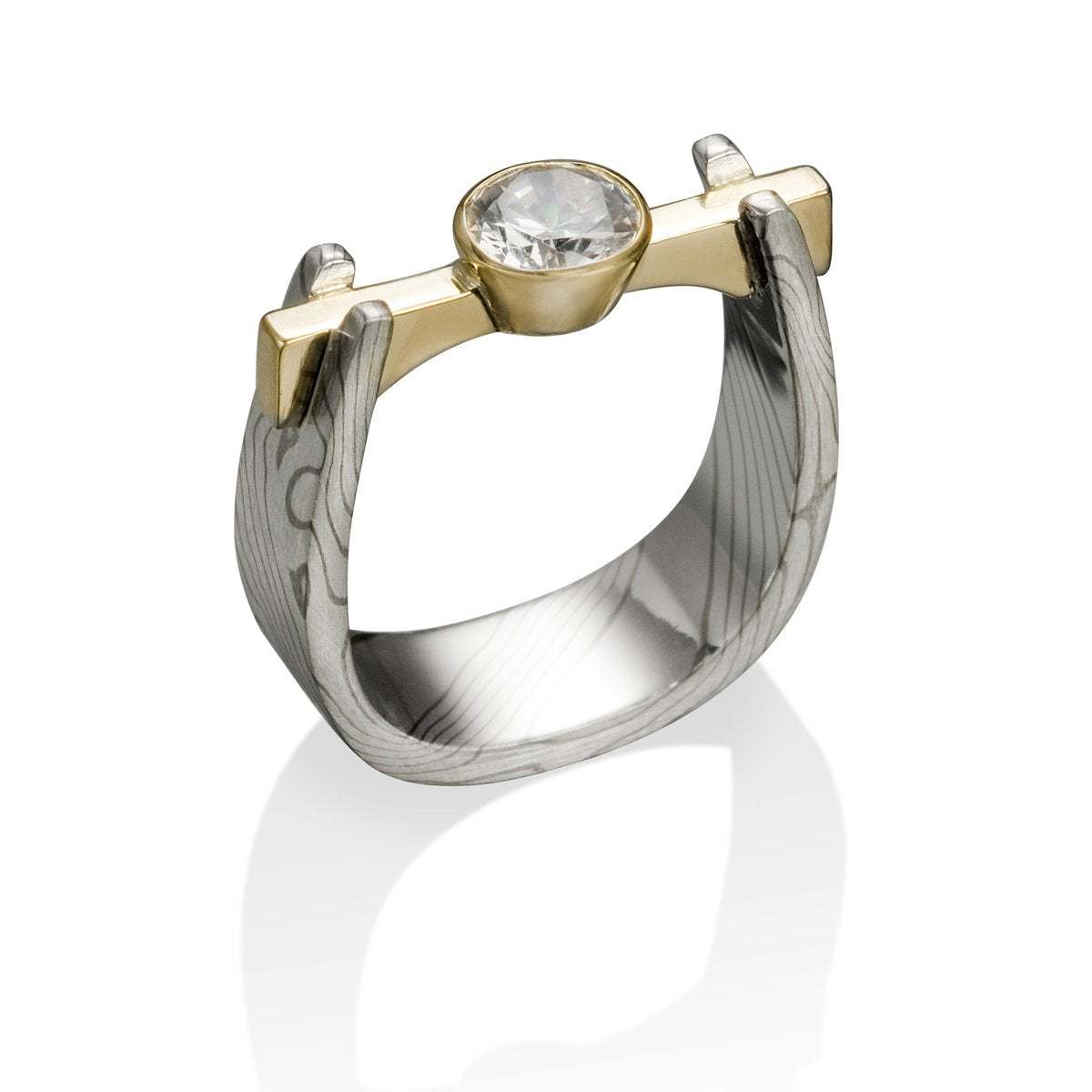 Two-tone gold ring with a round diamond and a Damascus steel band on a white background.