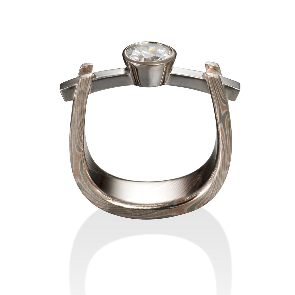 Two-tone titanium ring with a round diamond and a Damascus steel band on a white background.