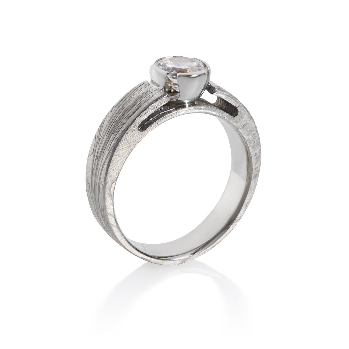 Silver ring with an oval-shaped diamond and a textured band on a white background.