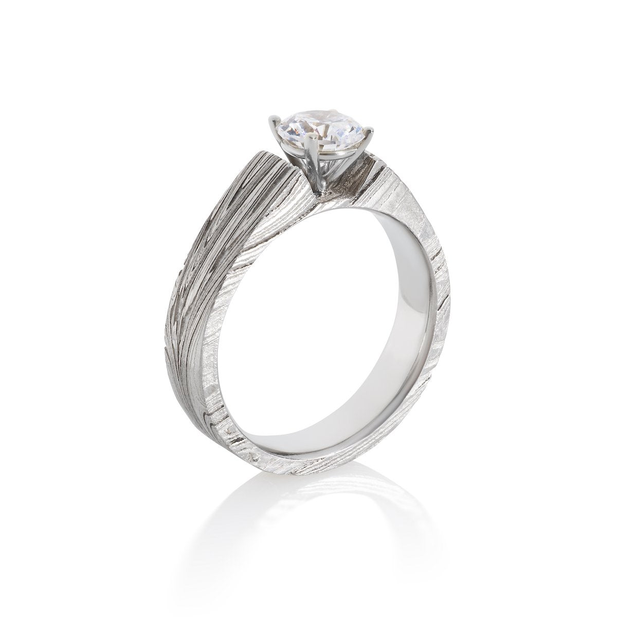 Silver ring with a round diamond and a Damascus steel band on a white background