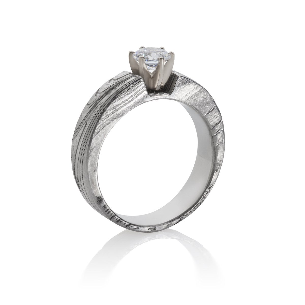 Silver ring with a round diamond and a Damascus steel band on a white background