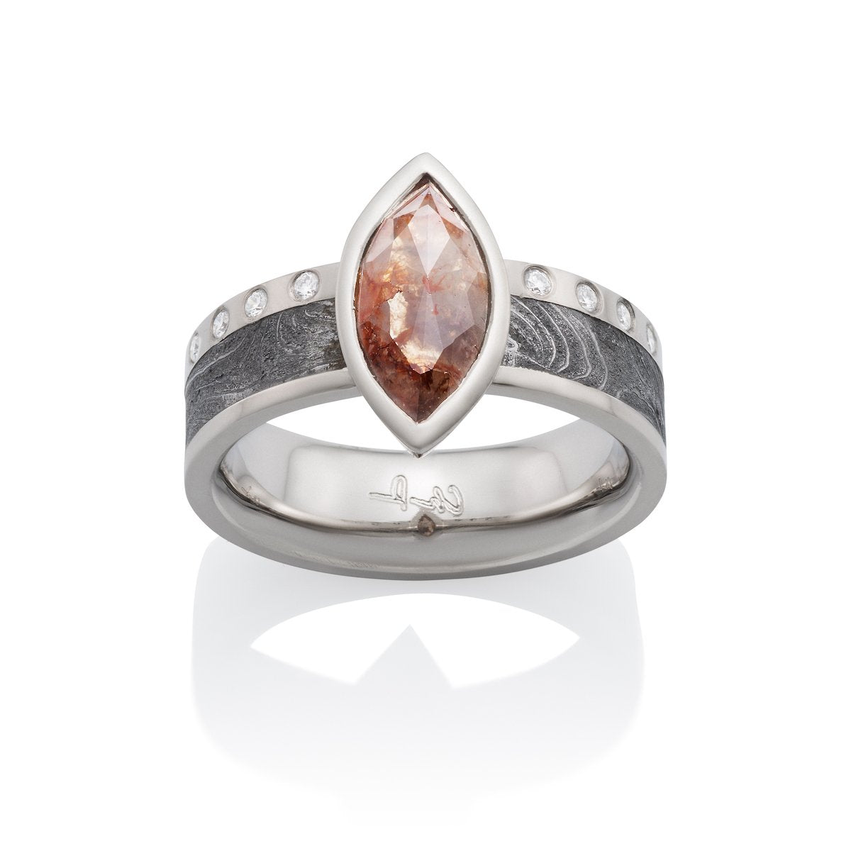Silver ring with a marquise-cut pink diamond, diamond accents, and a Damascus steel band on a white background