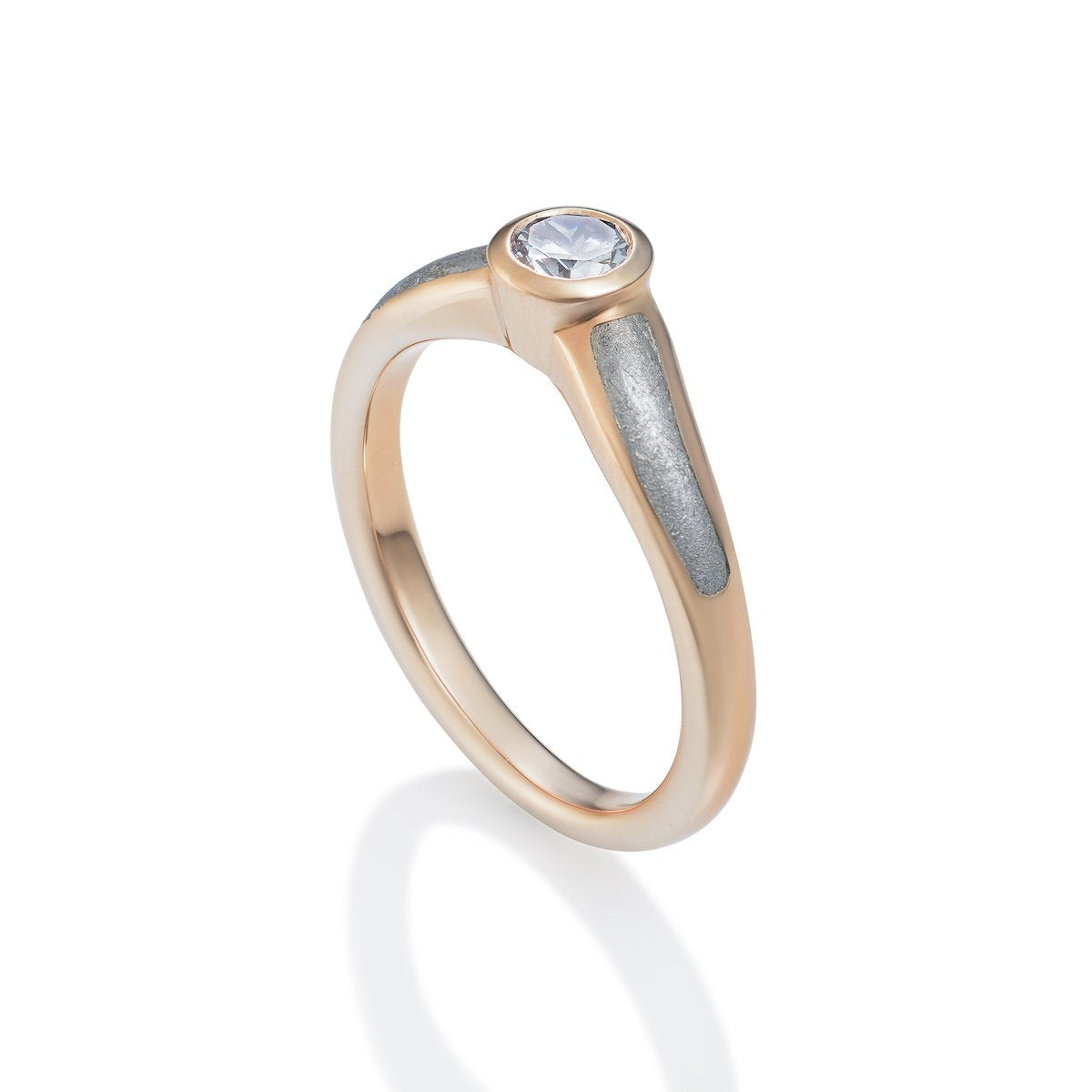 Rose gold ring with a round diamond and a textured band on a white background.