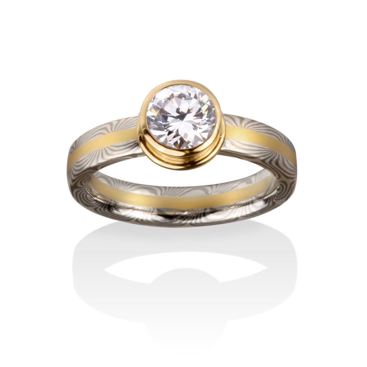 Two-tone gold ring with a round diamond and a Damascus steel band on a white background.