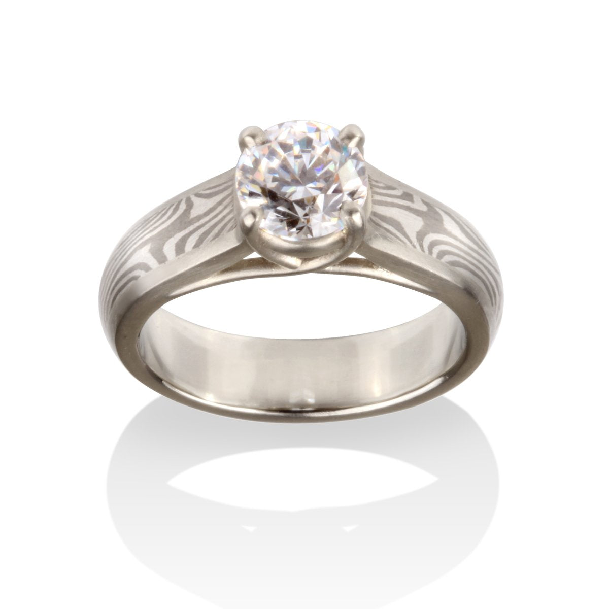 Titanium ring with a round diamond and a Damascus steel band on a white background.