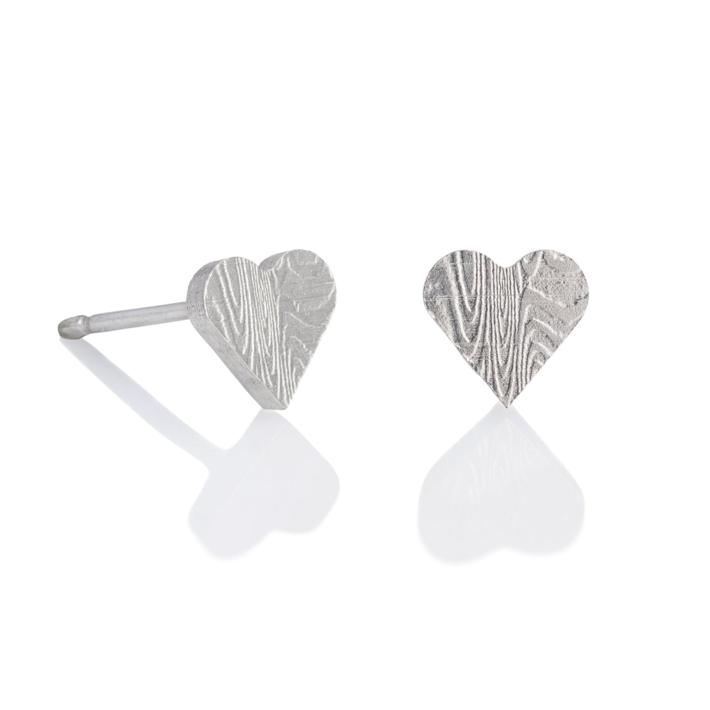 Pair of silver stud heart shaped earrings with a damascus steel pattern, on a white background.