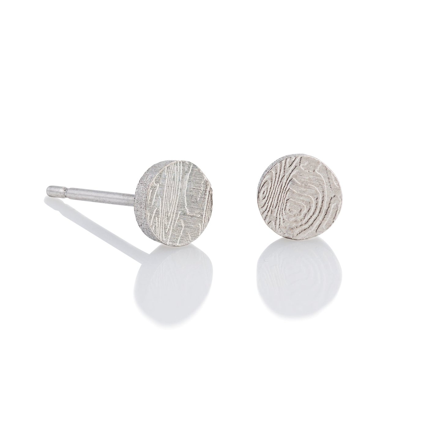 Pair of silver stud round shaped earrings with a damascus steel pattern, on a white background.