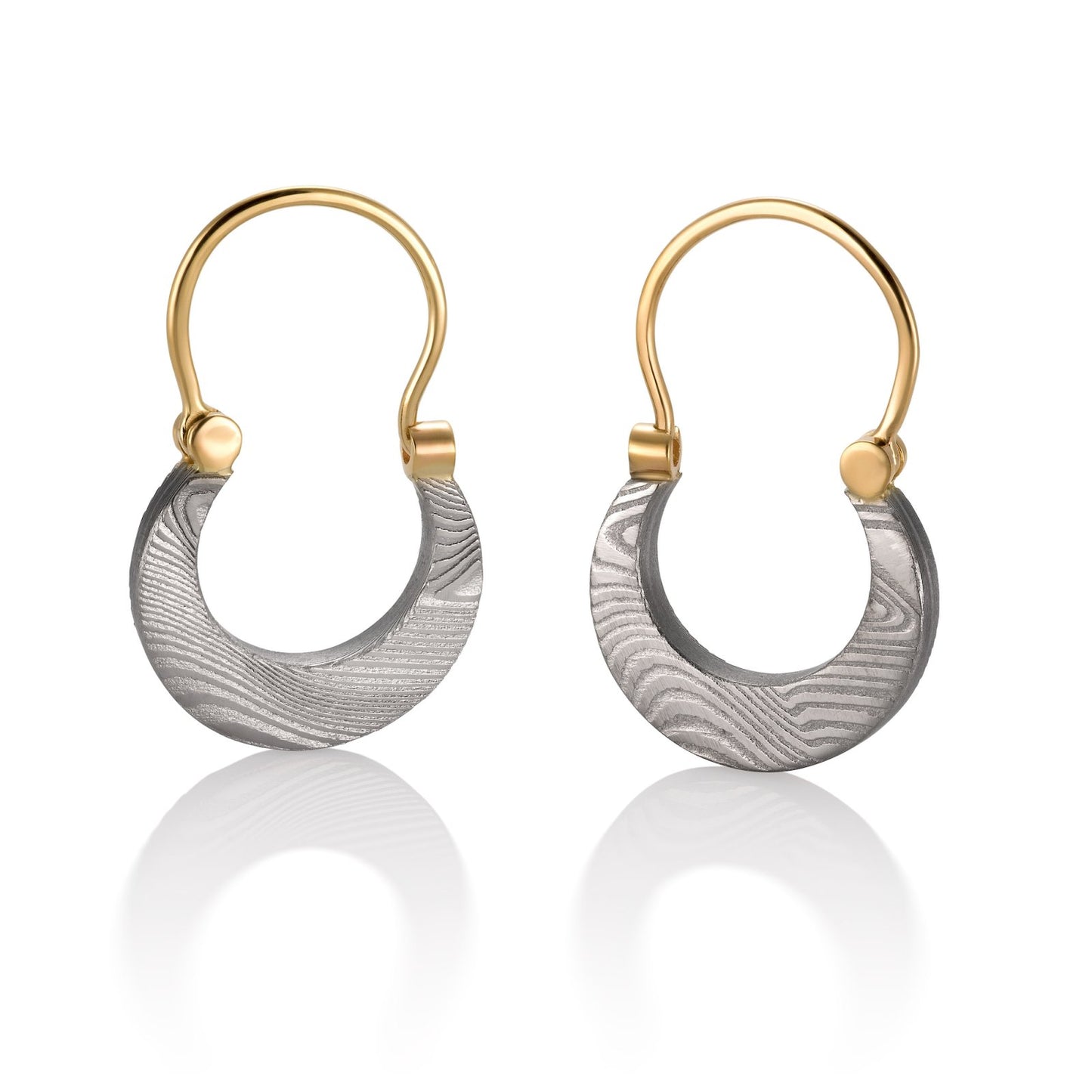 Pair of gold cresent shaped earrings with a damascus steel pattern, on a white background.