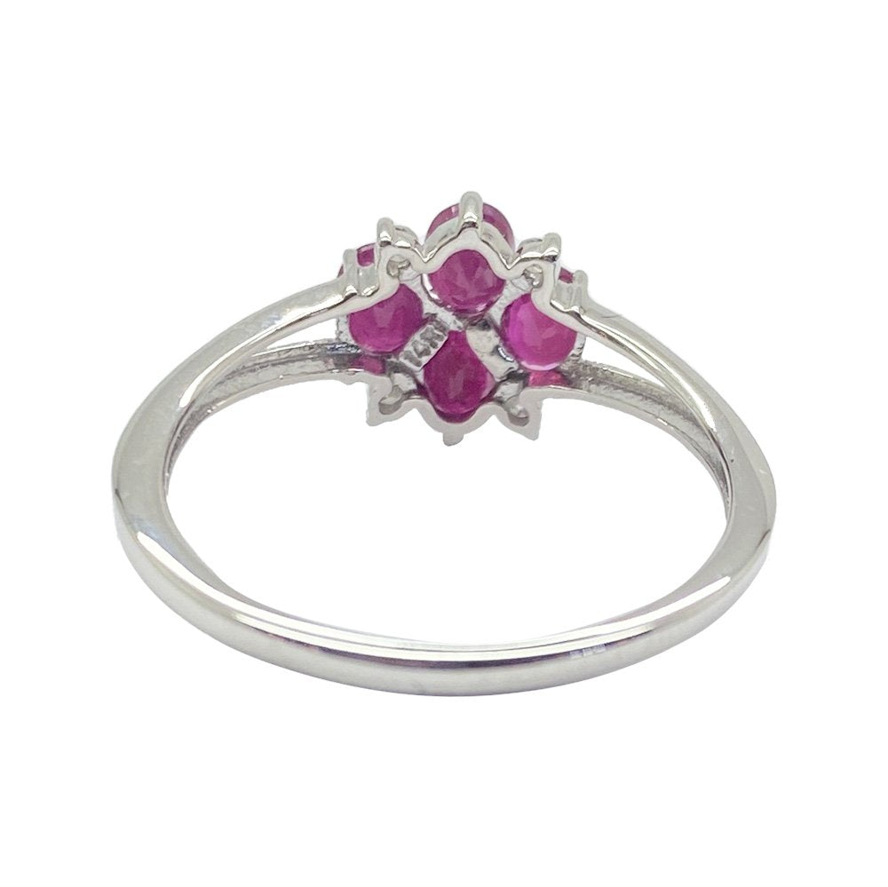 Back view of silver ring with a floral design featuring multiple rubies and diamonds on a white background