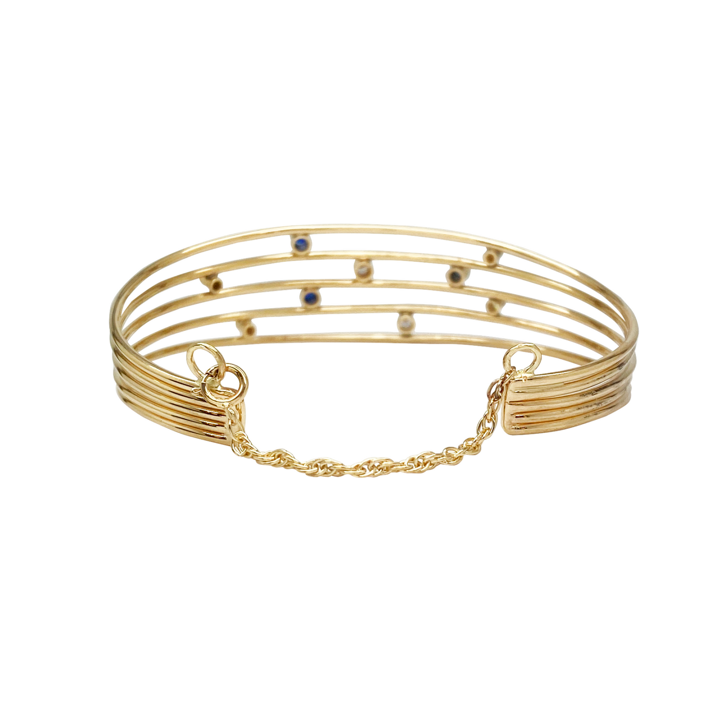 Multi-strand gold bangle bracelet with blue and clear beads.