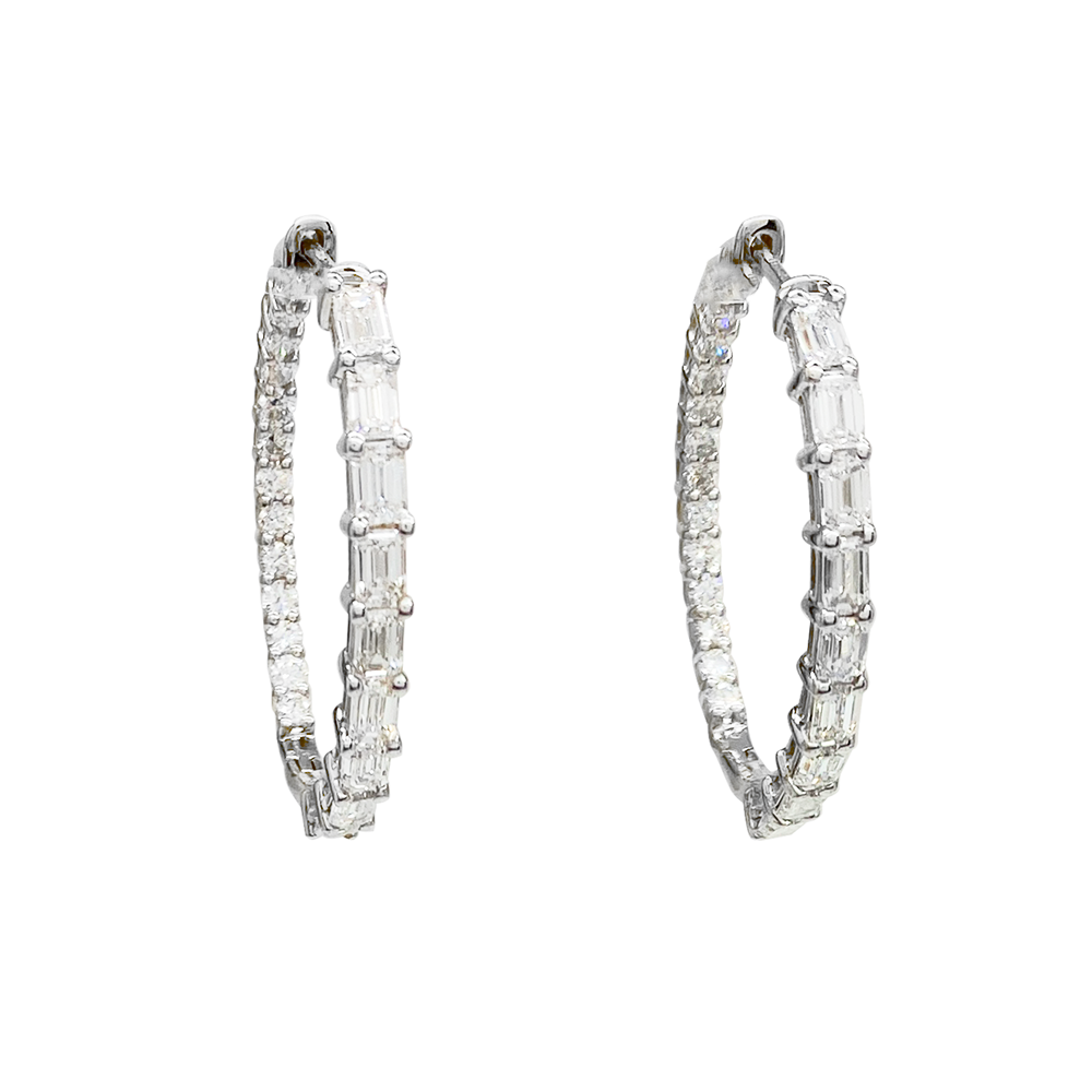 Silver hoop earrings with alternating round and emerald-cut diamonds on a white background.