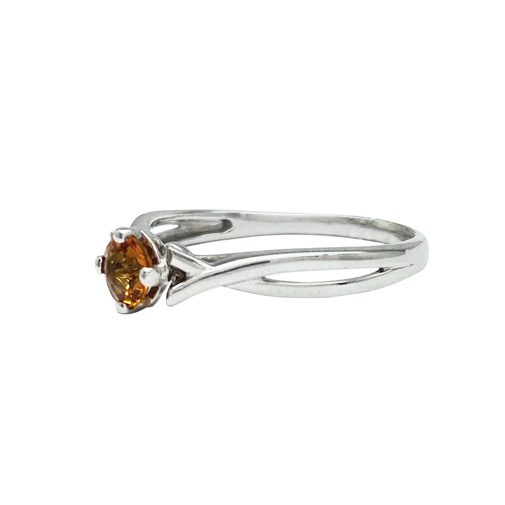 Silver ring with a marquise-cut orange center stone and diamond accents, on a white background.