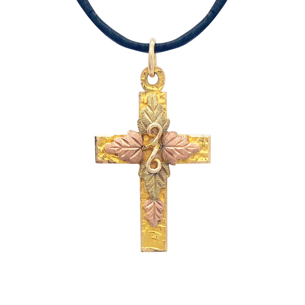 Tri-color gold cross pendant with a leaf design on a white background.