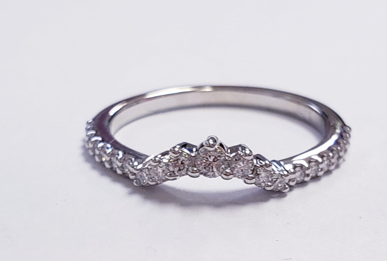 Silver ring with diamonds on a light gray background