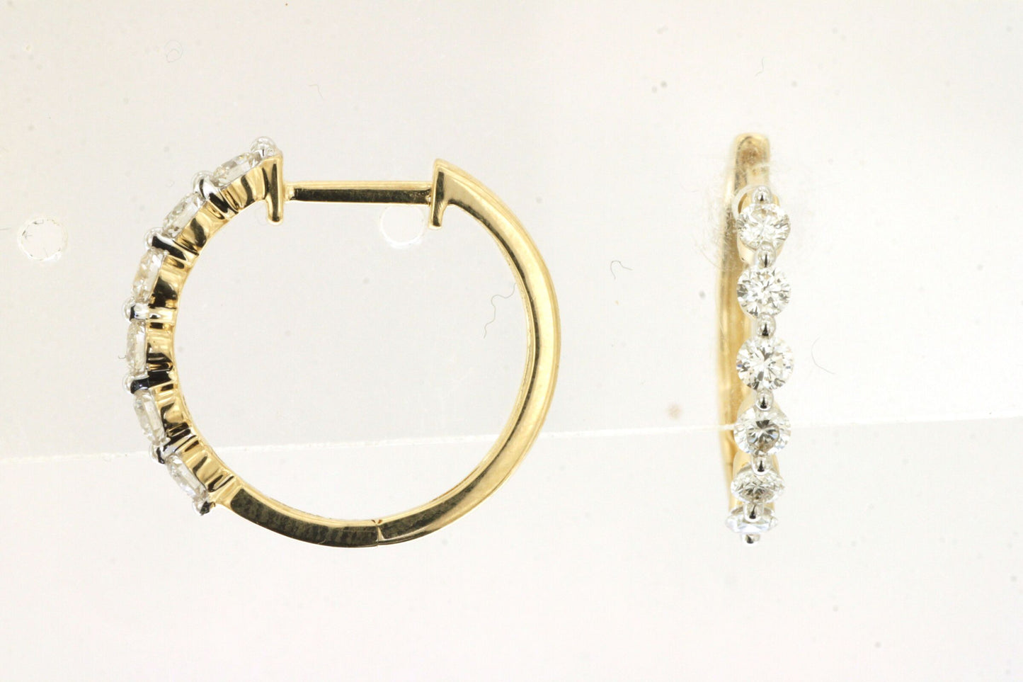 Gold hoop earrings with diamond accents on a light background