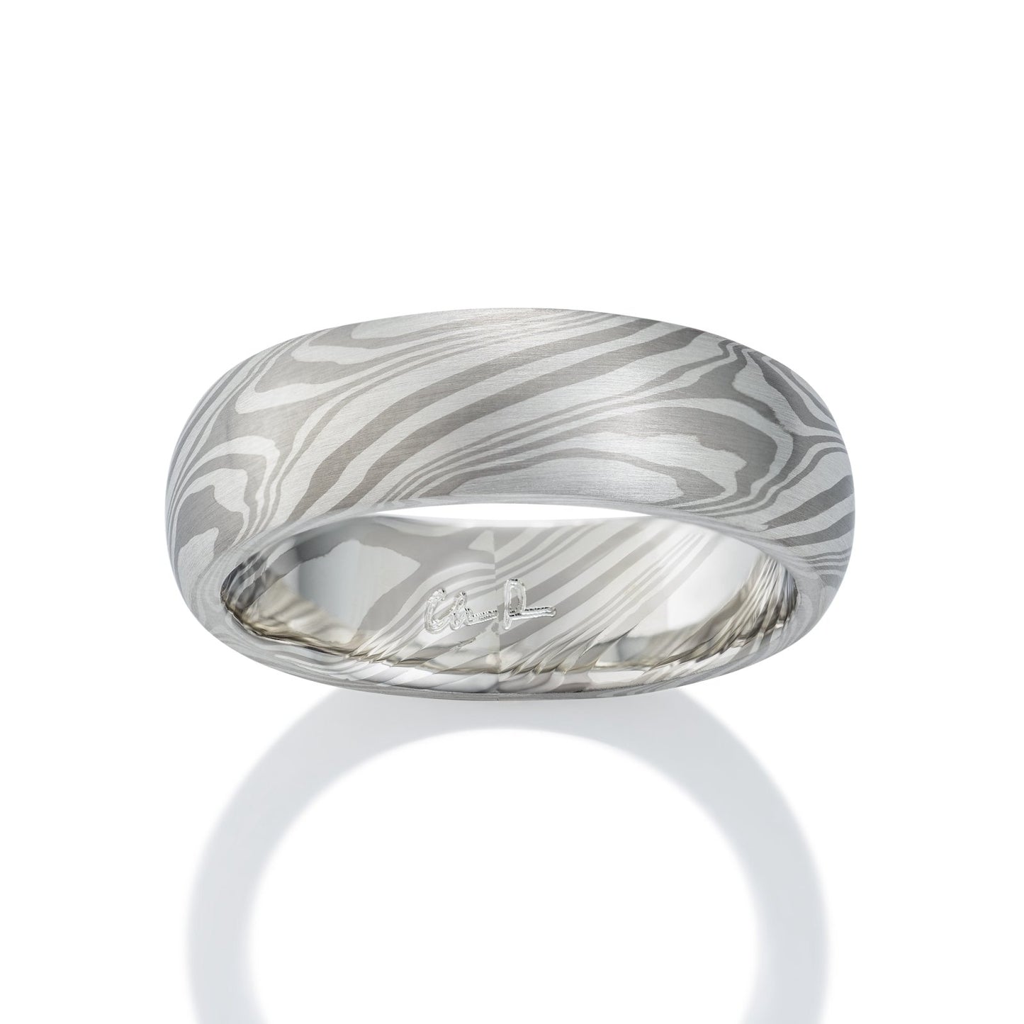 Damascus steel band ring on a white background
