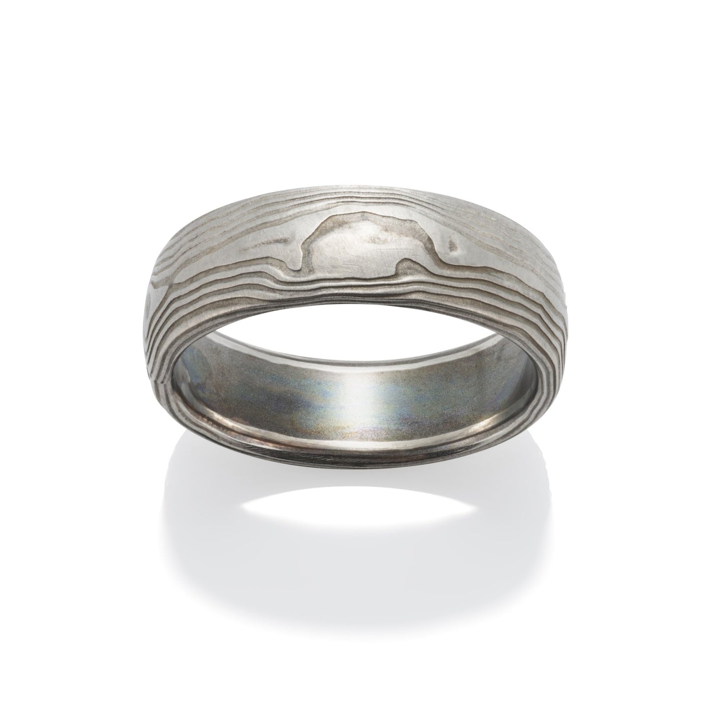 Damascus steel band ring on a white background