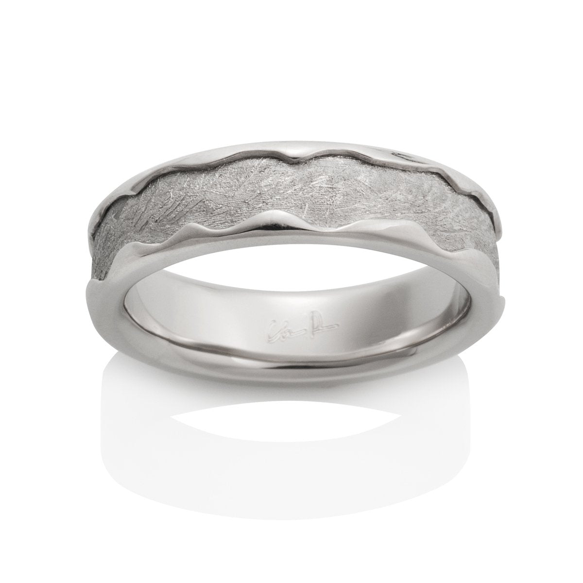 Silver ring with a textured, pattern on a white background