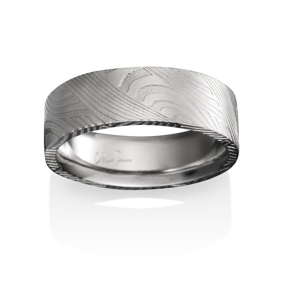 Silver ring with a textured, patterned surface on a white background